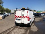 a white van parked in a parking lot with a ladder on the back of it
