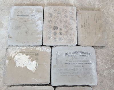 quatre sous-verres en pierre posés les uns à côté des autres sur un sol carrelé