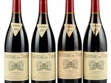 three bottles of red wine are lined up on a white surface