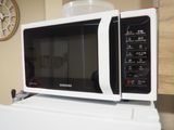 un micro-ondes posé sur un réfrigérateur