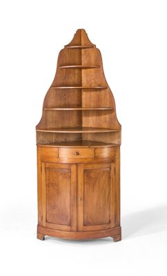 une armoire d'angle en bois surmontée d'une étagère