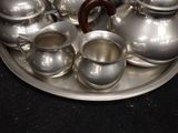 a silver tray with silver tea pots and cups on it