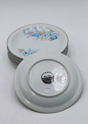 several white plates with floral designs are stacked on top of each other