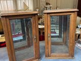 deux armoires en bois avec des portes vitrées, posées sur une table