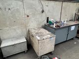 un espace de travail en béton équipé d'un établi, situé au milieu de la pièce