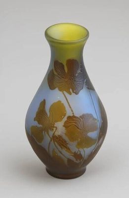 un vase bleu orné de fleurs jaunes, posé sur un fond blanc