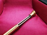 a baseball bat sitting in a case on a pink cloth