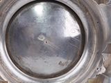 a silver vase with a hole in the middle of it