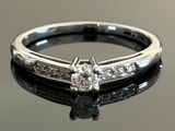 a close up of a diamond ring on a black surface