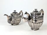 deux théières en argent et une théière sur fond blanc