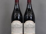 two bottles of red wine sitting on top of a glass table