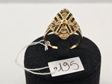 un gros plan d'une bague en or posée sur un présentoir noir