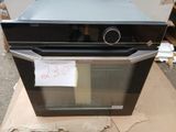 un four noir posé sur une boîte en carton