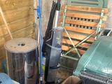 a pile of trash and a trash can in a garage