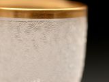 a close up of a glass with a gold rim