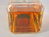 a small glass jar with a small square inside of it