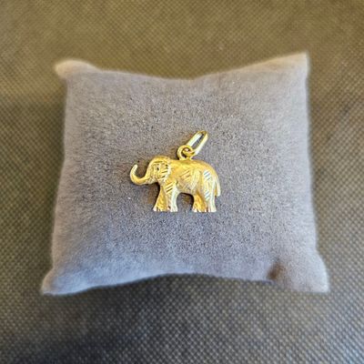 un petit éléphant en or posé sur un oreiller