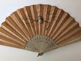 un ventilateur accroché au mur, sur lequel est posé un oiseau