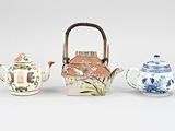three different types of teapots are lined up on a white surface