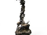 an antique bronze candle holder with a bird on top of it