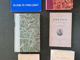 Plusieurs livres sont alignés sur une table devant un fond noir.