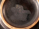 a close up of a black vase with a bird in it