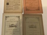 four old books are lined up on a white surface