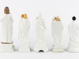 four figurines of jesus and other religious figures are lined up in a row