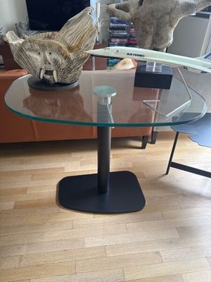 une table en verre avec un plateau en verre et un piètement en métal
