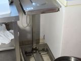 une petite cuisine équipée d'un évier, d'une cuisinière et d'une poubelle