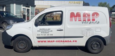 une camionnette blanche garée devant un bâtiment