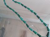 a green beaded necklace hanging from the ceiling of a room