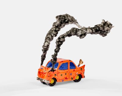 une petite voiture miniature d'où sort de la fumée