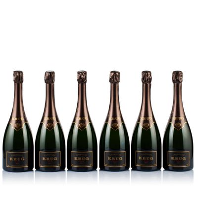 six bottles of champagne lined up against a white background
