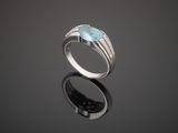 a close up of a silver ring with a blue topaz stone