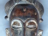 an image of a close up of a wooden mask on a wall
