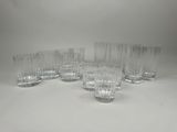 un lot de six verres à eau en verre transparent posés sur un plan de travail blanc