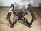 a wooden table with a glass top on a tiled floor