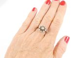 a woman ' s hand with a diamond ring on it