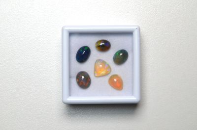 plusieurs pierres de différentes couleurs dans une boîte blanche posée sur une surface blanche