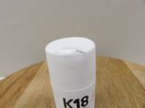 a bottle of k18 on a wooden table