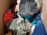 a cardboard box filled with clothes and a hat