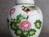 un vase sur lequel sont peints un oiseau et des fleurs