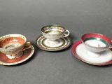 three cups and saucers are lined up on a table