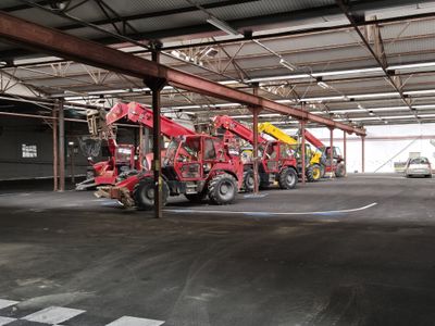 de nombreux camions rouges et jaunes garés dans un garage