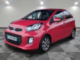 Une voiture rouge est garée dans un garage dont le sol est en damier.