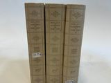 three books sitting on top of each other on a white surface