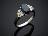 a blue sapphire and diamond ring on a black surface