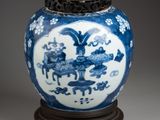 blue and white vase with a wooden stand on a gray surface