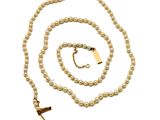 un gros plan d'un collier de perles muni d'un fermoir en or sur fond blanc